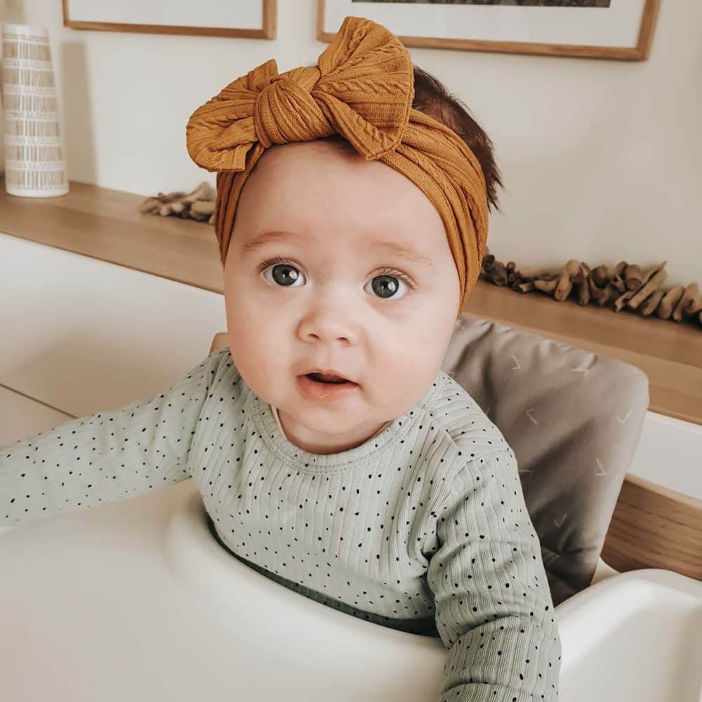 Baby med sennepsfarvet pandebånd