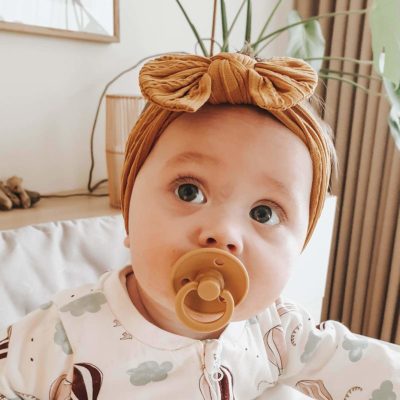 Baby med sennepsfarvet pandebånd